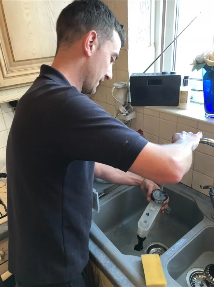Central heating power flush results showing clean water after sludge removal
